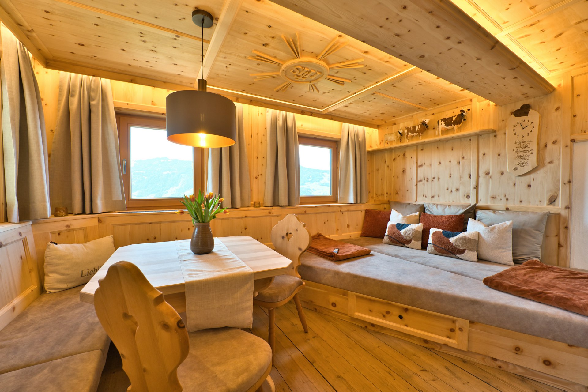 Cozy wooden room with seating and dining area.